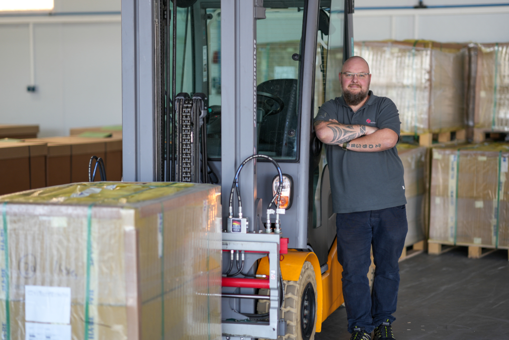 Mitarbeiter, der neben einem Stapler steht